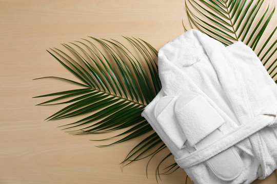 Flat lay composition with clean folded bathrobe on wooden background