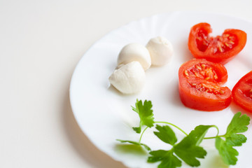 Tomato slices, mozzarella balls and sprigs of parsley