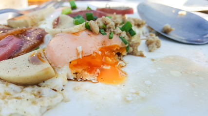 The egg yolk flows out of the fried egg.