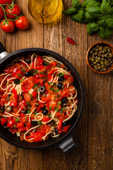 Italian spaghetti alla Pultanesca with tomatoes and olives. Served without meat and cheese.