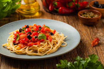 Italian spaghetti alla Pultanesca with tomatoes and olives. Served without meat and cheese.