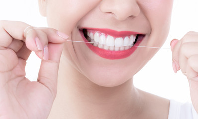 Fototapeta premium Close up images of young pretty woman, smiling, beautiful white and clean teeth, are using dental floss Clean teeth after eating For good dental health On white background to health care concept