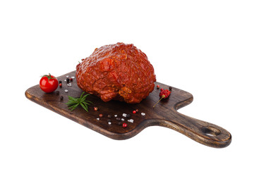 Packshot. Cooked, smoked ham entirely on a wooden board, decorated with spices.