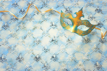 Blue and gold elegant traditional venetian mask over vintage wooden background