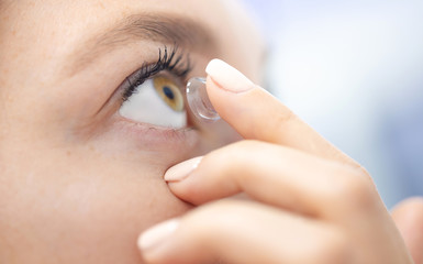 Young girl puts on contact lenses
