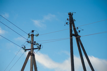Fototapeta premium Close-up of old power lines against the blue skies and clouds