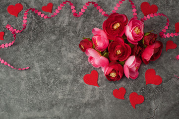 Holiday background for Valentine's Day on a gray cement background with hearts, gifts and a ribbon.
