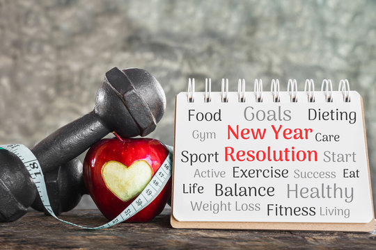 new year goals for sport concept with red apple,dumbbell and resolution list on paper 