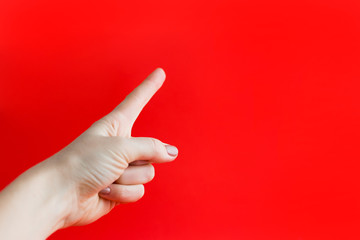 Hand finger pointing isolated on red background. Woman hand with index finger