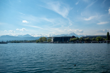 Fototapeta na wymiar Charming scene of modern building beside the Lucerne lake on mountains and blue sky with clouds background, copy space, Luzern, Switzerland