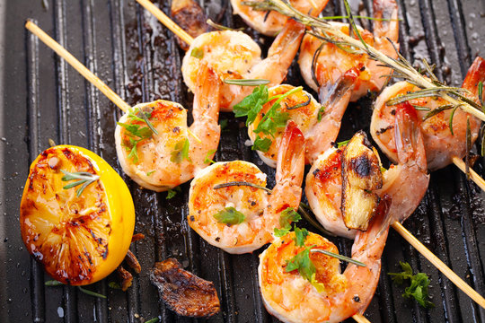 grilled shrimp on skewers. Grilled seafood on skewers with spices, herbs and lemon. delicious prawn. Grill. The iron grill. close up