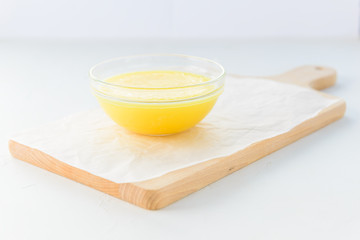 Ghee in a bowl on a wooden board.
