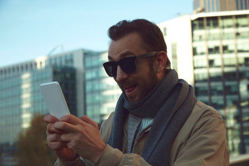 Handsome man using cellphone while enjoying in Paris.