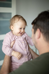 Father playing with his baby girl at home. Family, fatherhood concept