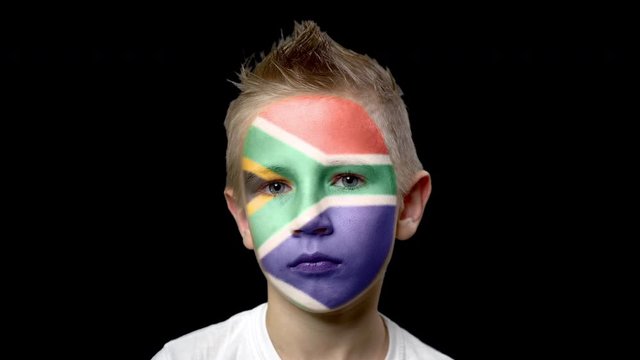 Sad fan of the football team of South Africa. A child with a face painted in national colors. Unhappy boy with sad eyes. Fiasco of your favorite team. Disappointment. Sadness. Experience. Failure. 