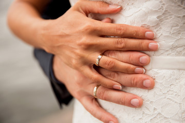  a pair of newlyweds hands with wedding rings