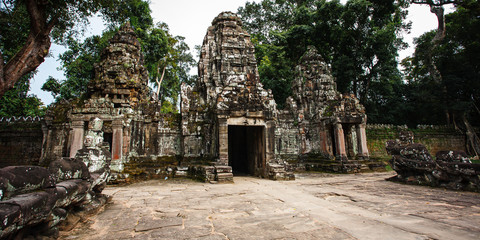 Fototapeta premium Temples of Angkor Wat where the jungle has partially overgrown the ruins near the city of Siem Reap in Cambodia