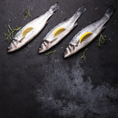 fresh raw whole sea bass. Raw seabass fish with spices and herbs ingredients. Top view with copy...