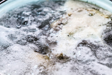 Boiling foam in a saucepan on an electric stove