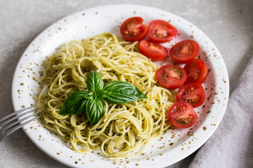 Spaghetti with homemade pesto sauce, basil leaves and  tomatoes/