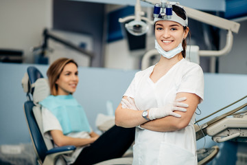 portrait of positive smiling dentist woman in white uniform looking at camera, careful doctor in dental office, professional worker of clinic