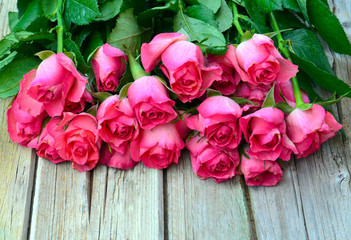 Obraz na płótnie Canvas Bouquet of pink roses on old wooden background.Valentine's Day,Mother's Day or Birthday gift concept with copy space.Selective focus.