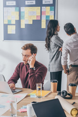 selective focus of businessman talking on smartphone near scrum masters