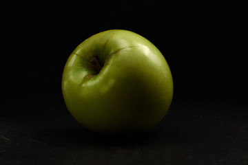 Green apple Simirenko at black background. 