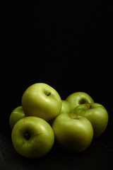Green apples Simirenko at black background. Vertical.