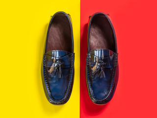 Men fashion leather tassel loafer shoes on red and yellow background. Top view