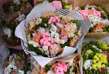 Many bouquets of  preserved flowers, pastel colors-green, pink, white, yellow. Non-allergenic, dry flowers, always alive. Sale in a flower shop. Selective focus