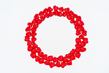 Bright red hearts are shiny, glass lie in the form of a round frame on a white background. Concept of love, marriage, wedding, Valentine's day, passion