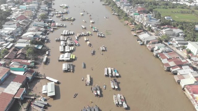 Aerial: flying over Cai Rang floating market in the morning, boats selling wholesale fruits and goods, Can Tho, Mekong Delta region, South Vietnam, tourism destination. native d-log cinelike