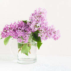 Branches of fresh purple lilac in glass vase