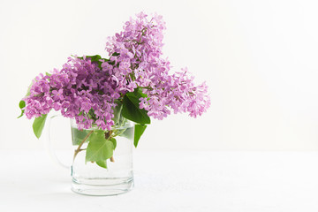 Branches of fresh purple lilac in glass vase