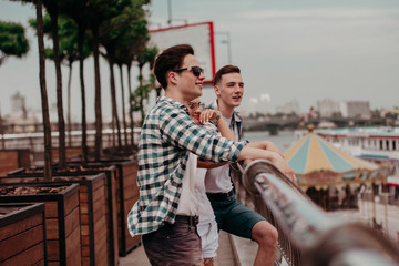 Three Young Friends On Bridge And Looking Out On The City.