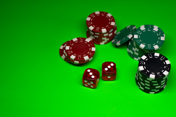 Gambling chips and game dice on the green poker cloth