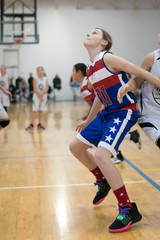 Young girl playing basketball on indoor court