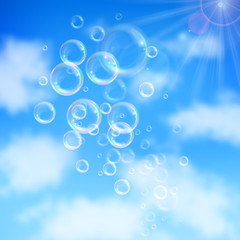 Realistic transparent floating soap bubbles on blue sky background. Design element for advertising booklet, flyer or poster
