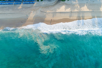 Aerial view sandy beach and waves Beautiful tropical sea in the morning summer season image by Aerial view drone shot, high angle view Top down.