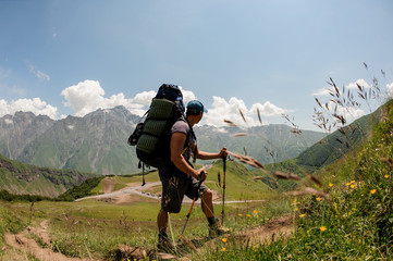 Fototapeta premium Hiker with backpack travels among hills and mountains