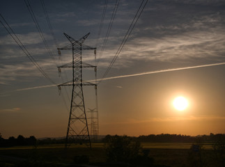 Linie przesyłowe energii elektrycznej  wysokiego napięcia na tle wieczornego nieba