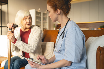 Attentive young doctor consulting her mature patient