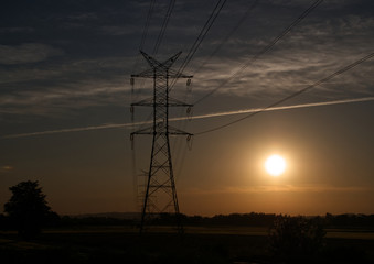 Linie przesyłowe energii elektrycznej  wysokiego napięcia na tle wieczornego nieba