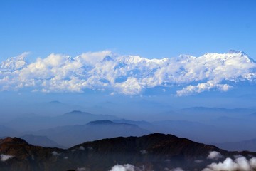 Fototapeta na wymiar The Himalayas in the coulds / Enormous of the Himalaya ranges above the cloud and layer of dust over Nepal