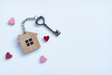 House key in heart shape with home keyring on old wood background decorated with mini heart - 314708424