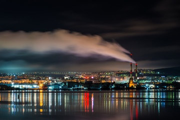 Naklejka na ściany i meble night Murmansk, city lights reflected in the Bay and the ships standing in the port