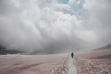 Small figure of traveller hiking near mountain