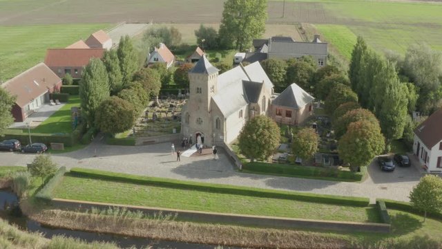Aerial of wedding in small historic church while people are waiting for bride