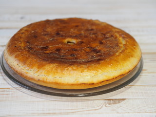 Round homemade pie with cabbage and river fish pike. Wooden rustic white table. Homemade food.